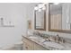 Bright bathroom featuring a granite countertop and a double sink vanity with a mirror at 8508 Zinfandel Pl, Raleigh, NC 27615
