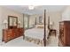 Bedroom featuring a four poster bed, side tables with lamps, and wooden dressers at 8508 Zinfandel Pl, Raleigh, NC 27615