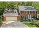 Charming two-story brick home featuring a two-car garage, dormer windows, and professionally landscaped front yard at 8508 Zinfandel Pl, Raleigh, NC 27615