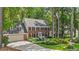 Charming two-story brick home featuring a two-car garage, dormer windows, and professionally landscaped front yard at 8508 Zinfandel Pl, Raleigh, NC 27615