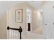 Hallway featuring carpeted floors, neutral walls with pictures, and multiple doors at 8508 Zinfandel Pl, Raleigh, NC 27615