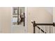 Bright hallway featuring stairs with dark wood railing and an open doorway to a bedroom at 8508 Zinfandel Pl, Raleigh, NC 27615