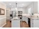 Bright kitchen featuring white cabinets, granite countertops, stainless steel appliances, and hardwood floors at 8508 Zinfandel Pl, Raleigh, NC 27615