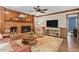 Bright living room with brick fireplace, wood paneled walls and decorative rug at 8508 Zinfandel Pl, Raleigh, NC 27615
