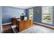 Office with blue walls, wood desk, and plush rug offers a quiet workspace at 8508 Zinfandel Pl, Raleigh, NC 27615
