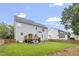 A large backyard with a lawn, a patio with chairs, and a wooden fence at 8912 Erinsbrook Dr, Raleigh, NC 27617