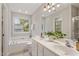 Bright bathroom with double vanity, soaking tub, and window providing natural light and garden views at 8912 Erinsbrook Dr, Raleigh, NC 27617