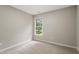 This bedroom has neutral walls and carpet and a window that lets in natural light at 8912 Erinsbrook Dr, Raleigh, NC 27617