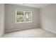 This is a carpeted bedroom with neutral paint and a window with a neighborhood view at 8912 Erinsbrook Dr, Raleigh, NC 27617