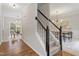 Elegant entryway featuring hardwood floors, a staircase with dark wood railings, and an open dining area at 8912 Erinsbrook Dr, Raleigh, NC 27617