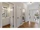 Hallway with a view of a half bathroom and a laundry room, with hardwood floors and white trim at 8912 Erinsbrook Dr, Raleigh, NC 27617
