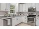 Bright kitchen featuring white cabinets, stainless steel appliances, and a view from the window at 8912 Erinsbrook Dr, Raleigh, NC 27617