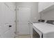Functional laundry room with modern washer and dryer, white cabinets, and tiled floors at 8912 Erinsbrook Dr, Raleigh, NC 27617