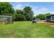 Large grassy backyard with a deck, greenhouse and outbuilding with plenty of space for outdoor activities at 914 Forest Dr, Garner, NC 27529