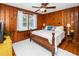 Bedroom featuring warm wood-paneled walls, hardwood floors, and a ceiling fan for comfort and style at 914 Forest Dr, Garner, NC 27529