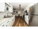 Well-lit kitchen with stainless steel appliances, ample counter space, and stylish white cabinetry at 914 Forest Dr, Garner, NC 27529