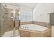 Bathroom featuring a shower, a soaking tub, and a window for natural light at 9530 Vira Dr, Raleigh, NC 27617