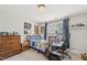 Well-lit bedroom featuring a window, a bed with colorful patterns, carpeted floors, and a desk at 9530 Vira Dr, Raleigh, NC 27617