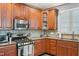 Close up of kitchen with wood cabinets, granite countertops, tile backsplash, and stainless-steel microwave and stove at 9530 Vira Dr, Raleigh, NC 27617