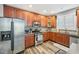 Kitchen with wood cabinets, stainless steel appliances, granite countertops, and wood-look floors at 9530 Vira Dr, Raleigh, NC 27617