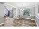 Spacious living room with dining area, light gray walls, wood-look floors, and natural light at 9530 Vira Dr, Raleigh, NC 27617