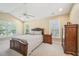 Spacious bedroom featuring a tray ceiling, fan, and windows providing natural light at 9530 Vira Dr, Raleigh, NC 27617
