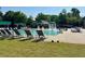 A swimming pool area with lounge chairs, umbrellas, and a grassy area for sunbathing and leisure activities at 9530 Vira Dr, Raleigh, NC 27617