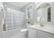 Cozy bathroom with a shower-tub combo, white vanity, and a decorative mirror above the sink at 9612 Treymore Dr, Raleigh, NC 27617