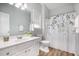 Clean bathroom with white vanity, toilet, and shower with floral curtain at 9612 Treymore Dr, Raleigh, NC 27617