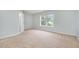 Bright bedroom featuring neutral carpet, light blue walls, and a window with a view to the outside at 9612 Treymore Dr, Raleigh, NC 27617