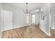 Dining area featuring hardwood floors, a chandelier, and access to other rooms at 9612 Treymore Dr, Raleigh, NC 27617