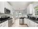 Bright kitchen featuring stainless steel appliances, granite countertops, and a breakfast nook with large windows at 9612 Treymore Dr, Raleigh, NC 27617