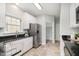 Well-lit kitchen with stainless steel refrigerator, white cabinets, and tile floors at 9612 Treymore Dr, Raleigh, NC 27617