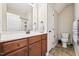 A well-lit bathroom with a vanity, toilet, and shower-tub combination behind a curtain at 1004 Lake Michael Way, Mebane, NC 27302
