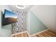 Small bedroom with colorful wallpaper and wood-look floors features a mounted television at 1004 Lake Michael Way, Mebane, NC 27302