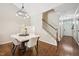 Dining area with hardwood floors, modern lighting fixture, and adjacent staircase, creating a welcoming atmosphere at 1004 Lake Michael Way, Mebane, NC 27302
