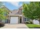 Charming brick townhome featuring a stone accent, black shutters, a white garage door, and a manicured lawn at 1004 Lake Michael Way, Mebane, NC 27302