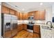 Well-equipped kitchen featuring granite countertops, stainless steel appliances, and rich wood cabinetry at 1004 Lake Michael Way, Mebane, NC 27302