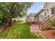 A backyard features a wood deck, a patio, a lush lawn, and mature trees at 101 Deerwalk Ct, Cary, NC 27513
