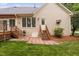 A backyard with a deck, patio, lush lawn, and exterior access to the home at 101 Deerwalk Ct, Cary, NC 27513