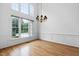 Formal dining room with hardwood floors, wainscoting, chandelier, and large windows offering a pleasant view at 101 Deerwalk Ct, Cary, NC 27513