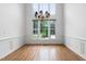 Formal dining room with hardwood floors, wainscoting, chandelier, and large bright windows at 101 Deerwalk Ct, Cary, NC 27513