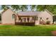 The back of a house with a wood deck, awning, lush lawn, and manicured landscaping at 101 Deerwalk Ct, Cary, NC 27513