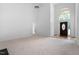 Spacious living room with carpet, soaring ceilings, a ceiling fan, and a decorative glass front door at 101 Deerwalk Ct, Cary, NC 27513
