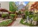 Serene backyard with a pebble walkway, manicured shrubs, and decorative stone features at 1012 Delta River Way, Knightdale, NC 27545