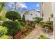 Landscaped backyard with mature trees, manicured bushes, and brick paver accents at 1012 Delta River Way, Knightdale, NC 27545