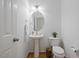 Powder room featuring a pedestal sink, an oval mirror, and a white toilet at 1012 Delta River Way, Knightdale, NC 27545