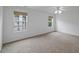 A carpeted bedroom with two windows, allowing natural light and offering views at 1012 Delta River Way, Knightdale, NC 27545