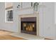 A fireplace with mantel sits centered between two windows and next to hardwood floors at 1012 Delta River Way, Knightdale, NC 27545
