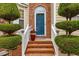 Inviting brick entryway showcasing a blue front door, manicured shrubs, and decorative plants at 1012 Delta River Way, Knightdale, NC 27545